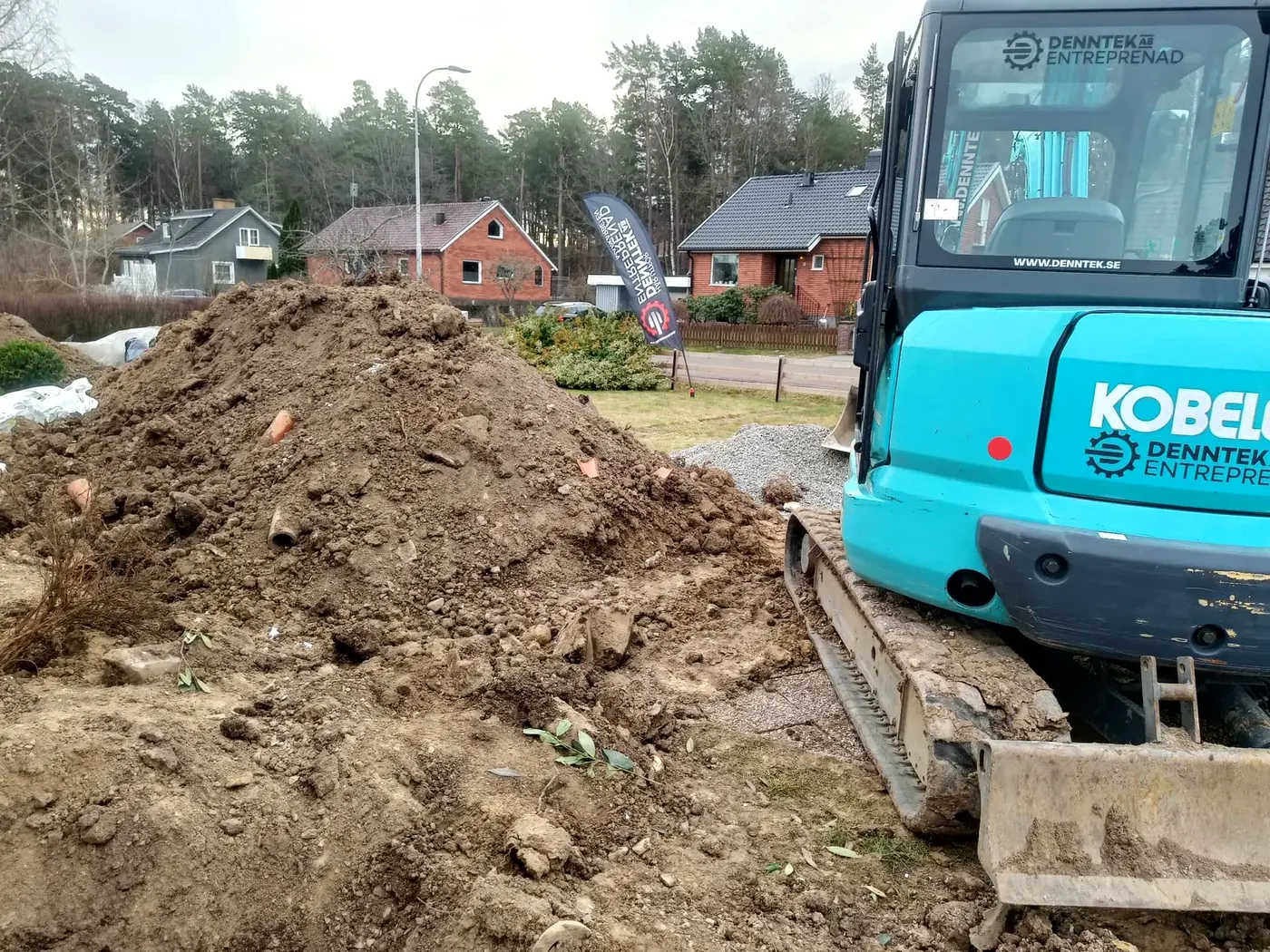 Grävmaskin från Denntek Entreprenad AB vid ett dräneringsarbete på en villatomt i Linköping